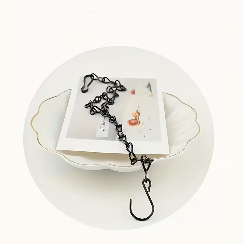 Black metal zipper hook on a white plate with a white background