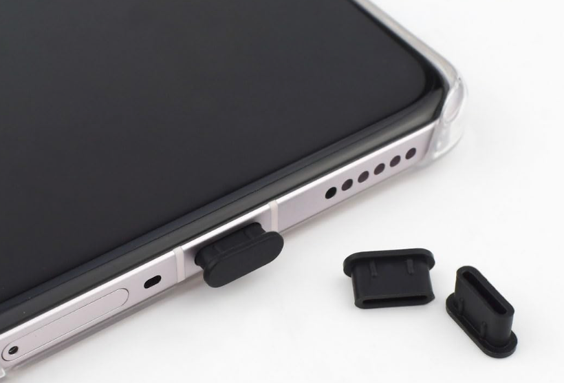 Smartphone with black rubber plug and additional black rubber plugs on a white background
